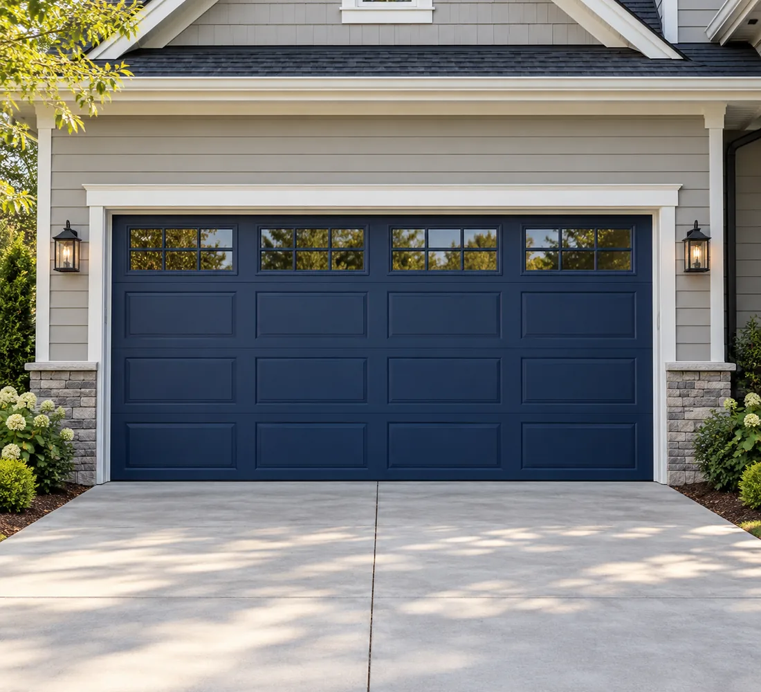 Illustrative photograph of a navy sectional garage door on a modern residential home